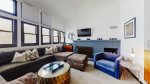 Features a cozy living area with a brick fireplace and hardwood floors